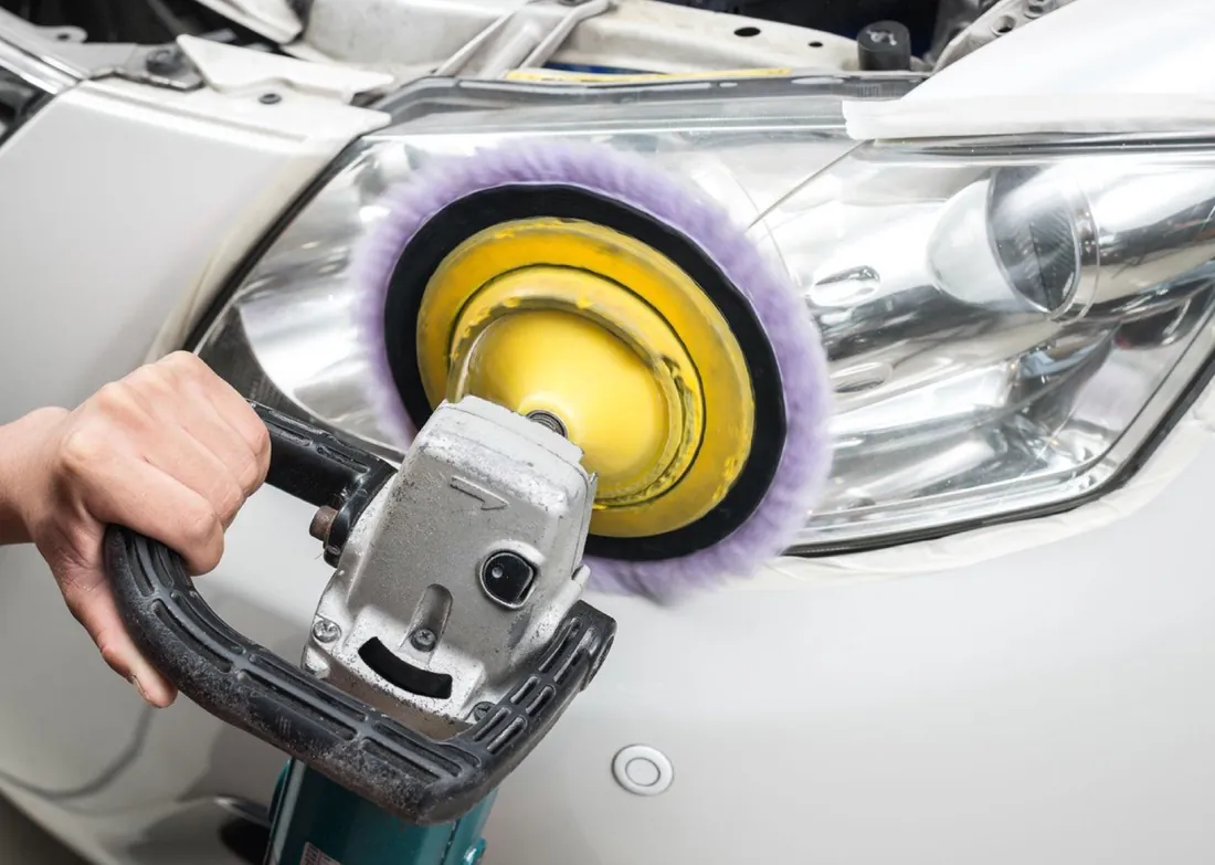 Rotary buffer with a yellow pad polishing beside a headlight